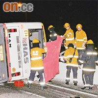 消防員用毛氈遮掩搬運屍體。