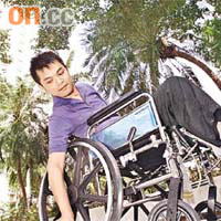 坐在輪椅的吳志雄向記者示範彎腰拾電話。