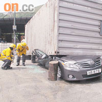 消防員檢查被壓扁的私家車。