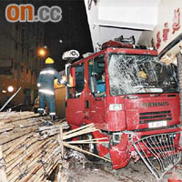 消防泵車撞向茶餐廳鐵閘，嚴重損毀。
