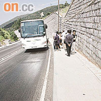 巴士在布滿油漬路面無法前行，乘客下車等候轉車。