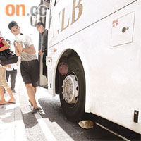 巴士車長用石塊楔着車輪，防止巴士滑行。