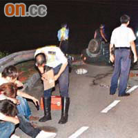 傷者從「反肚」私家車爬出，坐在路邊待送院。