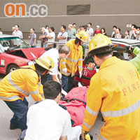 的士失控溜後撞向後車，救援人員將昏迷司機抬出送院。