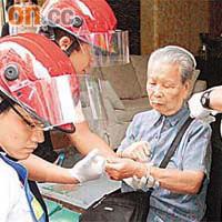 救護員替跌傷婆婆包紮傷口。