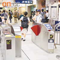 職員在入閘機旁呼籲乘客小心。