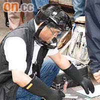 探員戴上防護面罩檢查電槍。