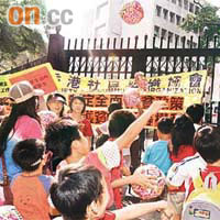 約二百名基層市民請願，將寫上貧窮的氣球踢入政府總部，寓意踢走貧窮。	何天成攝