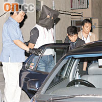 疑犯被押往其汽車搜查。