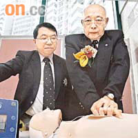 聖約翰救護機構代表李家仁醫生（左）及王祖耀（右）示範如何使用心臟除顫器為病人急救。