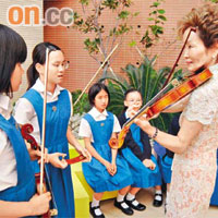 西崎崇子即場指導聖保羅小六學生拉小提琴嘅技巧。