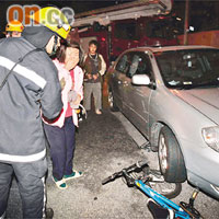 單車被私家車輾過，傷者女親友情緒激動。