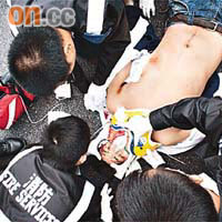 救護員為男子包紮傷口。