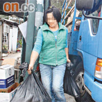 女店員手拿兩袋戰利品。