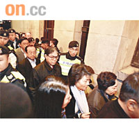 鄭汝樺（右）及一眾議員凌晨在警員保護下離開立法會。