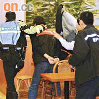 涉案疑兇被警員扣上手銬押走。