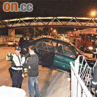 私家車橫擱石壆，司機（左二）涉「索K」被警員拘捕。