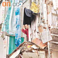 唐樓倒塌後多人被困瓦礫中，在旁樓宇一名女住客揮手求救。
