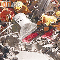 消防員在瓦礫中掘出童慶濤遺體。
