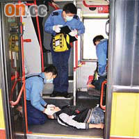 消防處救援人員將昏迷男子抬落巴士下層急救。