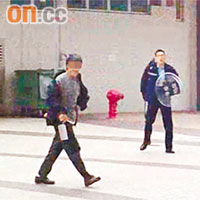 怪漢持刀亂舞，警員在旁監視。	讀者杜先生提供