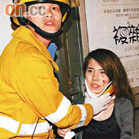 消防員為一名女途人戴上頸箍送院。