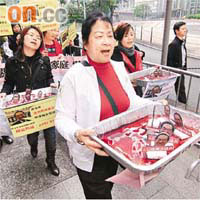 二十多名中港婦女拿着「酒池肉林」遊行至政府總部。