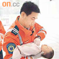 救護員為男嬰進行心外壓急救。