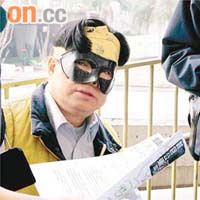 男子戴上蝙蝠俠眼罩在天橋頂抗議。