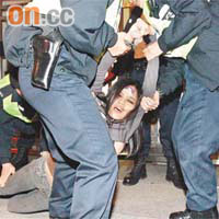 陳巧文昨晚在中聯辦門外集會時多次衝擊鐵馬及警方防線，警員抬她返回示威區。