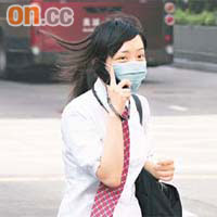 學生戴着口罩講電話，避免吸入污濁空氣，引致不適。