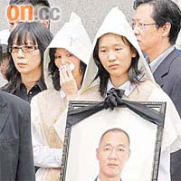 抵達浩園時，楊妻不停拭淚，獨女手捧父親遺像面容哀傷。