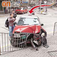 肇事的士衝落斜路撞毀鐵欄（箭嘴示），車頭損毀嚴重。