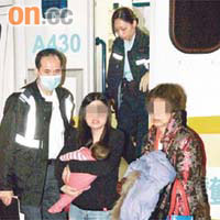 藍田<br>女事主抱着女兒由親友陪同送院治療。