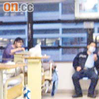 伊朗青年進食時，兩名警員在旁看守。
