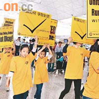 聯航員工帶同子女到機場聯航登機櫃位遊行一圈抗議。