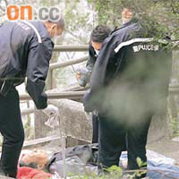 警員檢走麻繩及檢查死者屍體。