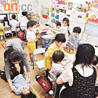 元岡幼稚園採「混齡」教學，不同年齡的學生於同一課堂中自由看書、玩電腦等。