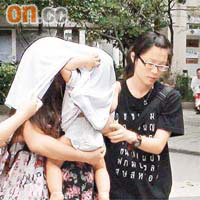 涉打傷丈夫的少婦抱着嬰兒被帶署調查。