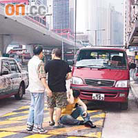 男子被的士撞傷，坐在地上等候送院。