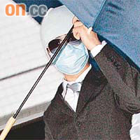 被告吳漢強昨日離庭時戴上口罩、張開雨傘遮擋，以免真面目曝光。