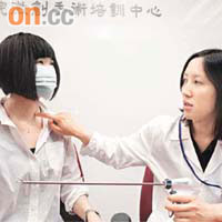 簡美儀（右）指若劉小姐接受傳統手術，頸部恐會留下疤痕。簡手持的為做內窺鏡手術的特別儀器。