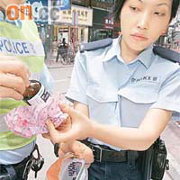 女警檢查檢獲的咳藥水。