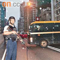 警員手持長槍在解款車旁戒備。