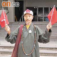 古佛禪寺的僧侶釋虛濟昨日離庭時雙手分持小型國旗和區旗。