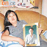 王素霞手捧丈夫遺照哭訴：「都是地下六合彩害死我老公。」