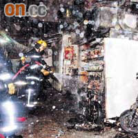 消防員向燒毀的電單車開喉灌救。