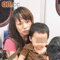 遭打傷婦人抱着兒子送院。