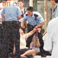 死者妻子跪屍痛哭，要由警員安慰。