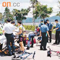 救護員在兩輛單車翻側現場救治傷者。